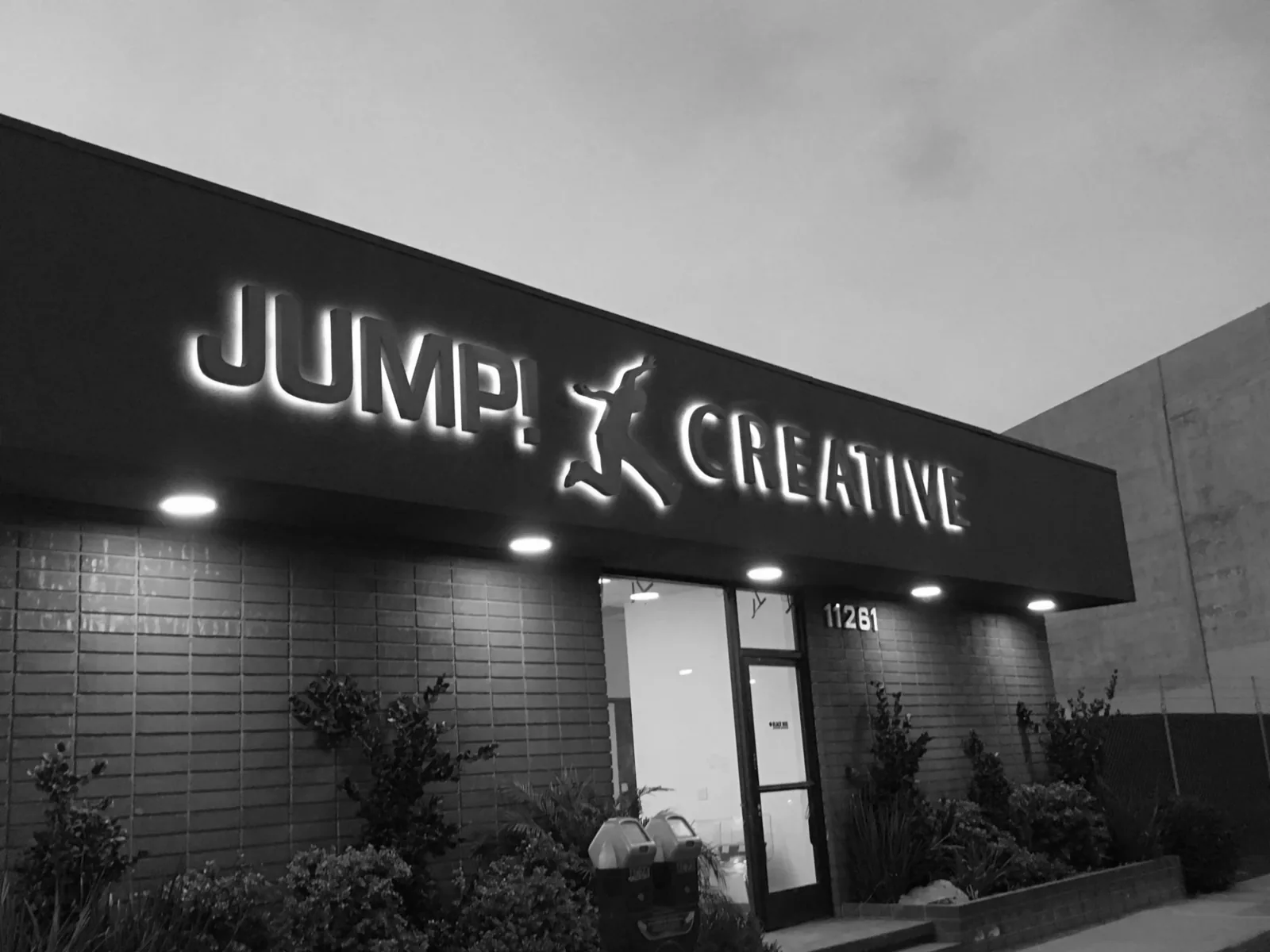 The Jump! Creative studio at dusk, the sign lit above the door